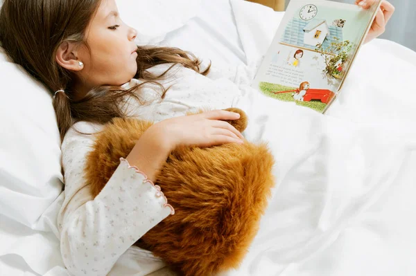 ベッドに横になって体温計を持っているテディベアの女の子 — ストック写真