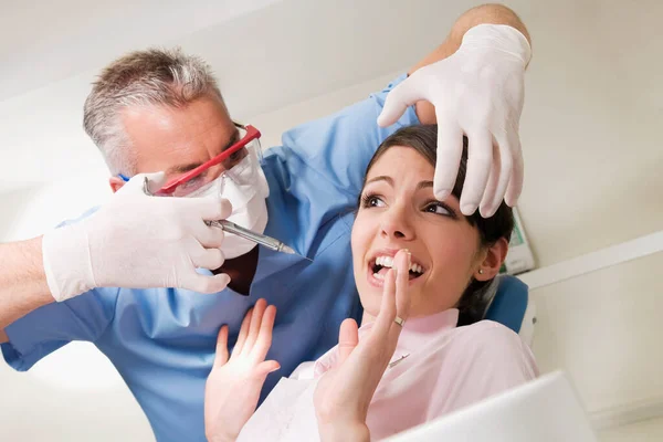 在牙科诊所检查病人的牙医 — 图库照片