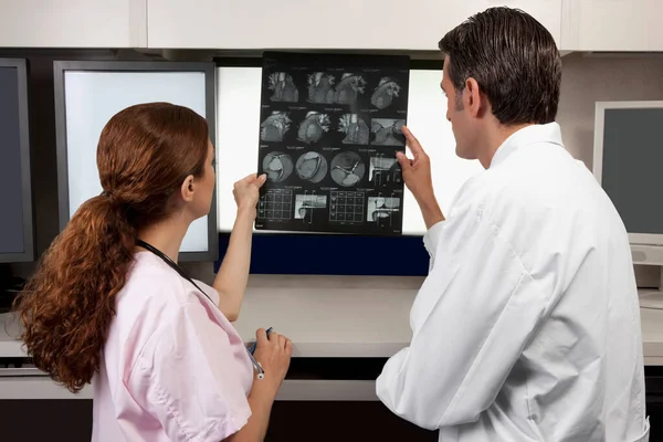 X線スキャンを見ている医師と女性の患者は — ストック写真