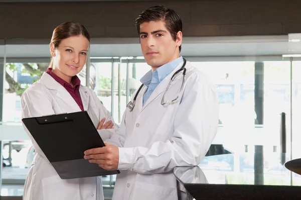 病院でデジタルタブレットを議論する若い医師と看護師の肖像画です — ストック写真