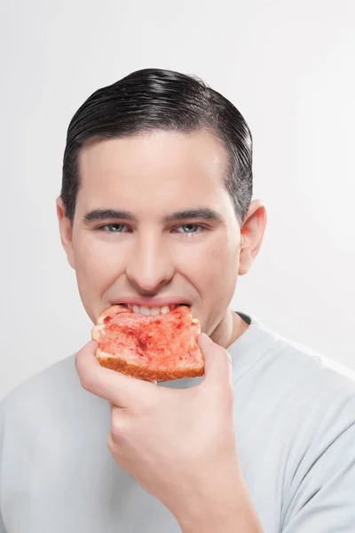 Junger Mann Isst Pizza Mit Rotem Pfeffer Auf Weißem Hintergrund — Stockfoto