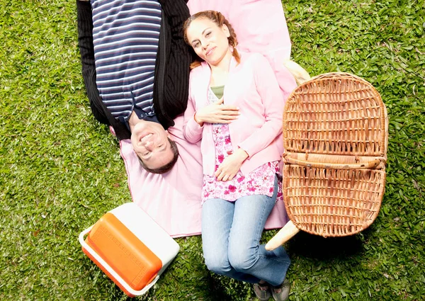 草の上にピクニックバスケットを持つ幸せな若い女性は — ストック写真