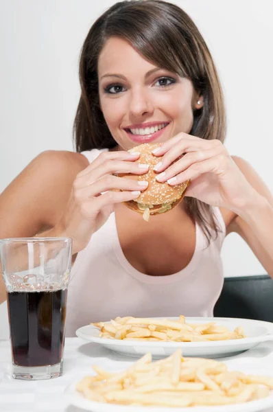 Jonge Vrouw Eten Hamburger Kijken Naar Camera — Stockfoto