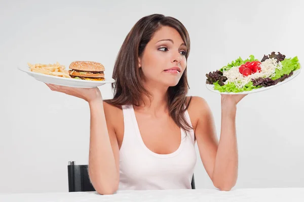 Νεαρή Γυναίκα Τρώει Burger Και Κοιτάζοντας Την Κάμερα Απομονώνονται Λευκό — Φωτογραφία Αρχείου
