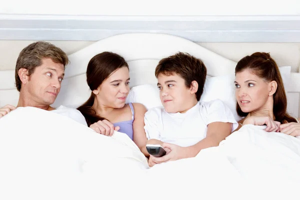 Счастливая Семья Лежит Кровати Смотрит Телевизор — стоковое фото