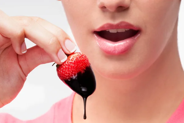 一个吃草莓的年轻女人的特写镜头 — 图库照片