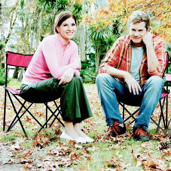 年轻夫妇坐在公园的长椅上谈恋爱 — 图库照片