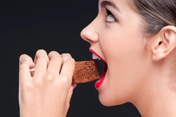 Jovem Mulher Comer Chocolate Chips Fundo Preto — Fotografia de Stock