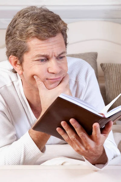 Senior Liest Buch Bett — Stockfoto