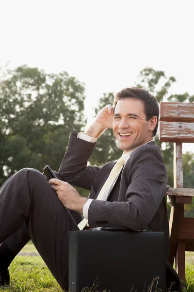 Portrait Smiling Businessman Sitting Bench Talking Mobile Phone Royalty Free Stock Images