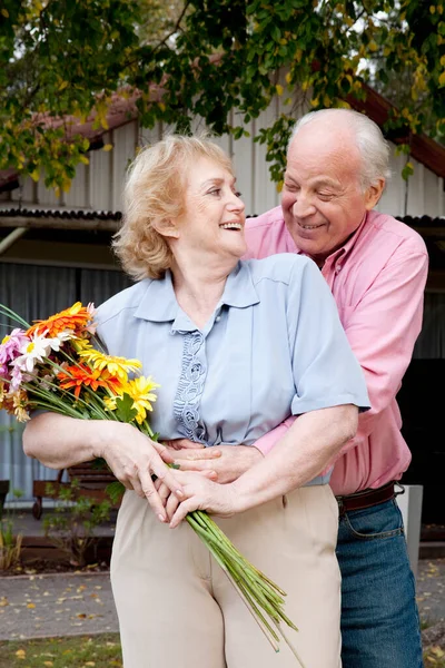 快乐的老夫妇 在公园里开着花 — 图库照片