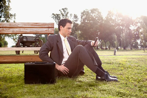 Geschäftsmann Sitzt Auf Bank Und Blickt Kamera — Stockfoto