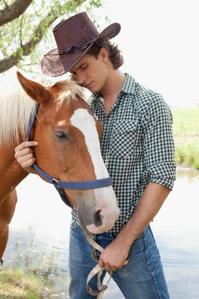 在田里牵着马的年轻人 — 图库照片