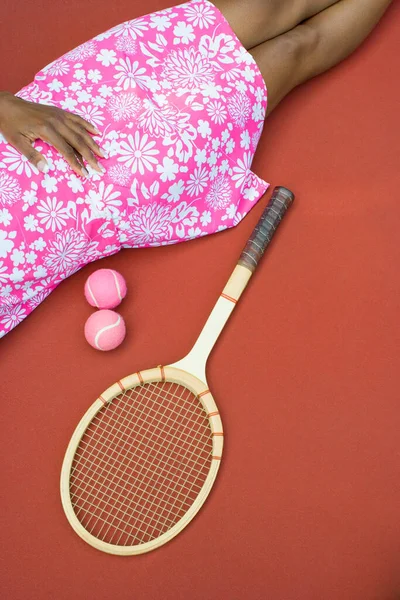 拿着球拍和粉色背景的球的女人 — 图库照片