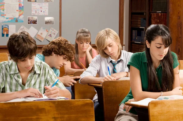 组的学生坐在教室的桌子前 — 图库照片
