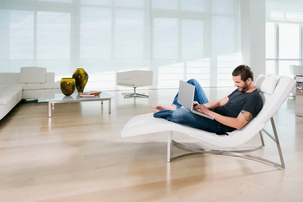 Jovem Sentado Sofá Usando Computador Portátil — Fotografia de Stock