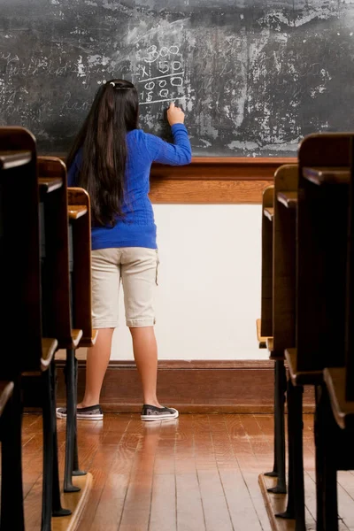 Masada Oturan Sınıfta Yazan Genç Bir Kadın — Stok fotoğraf