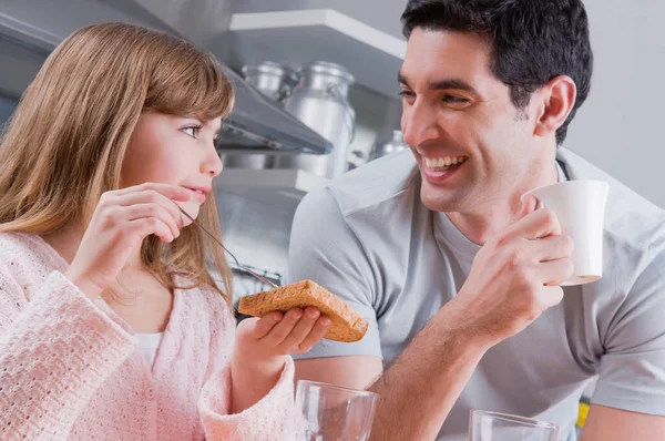 若いカップルがキッチンで朝食を食べ — ストック写真