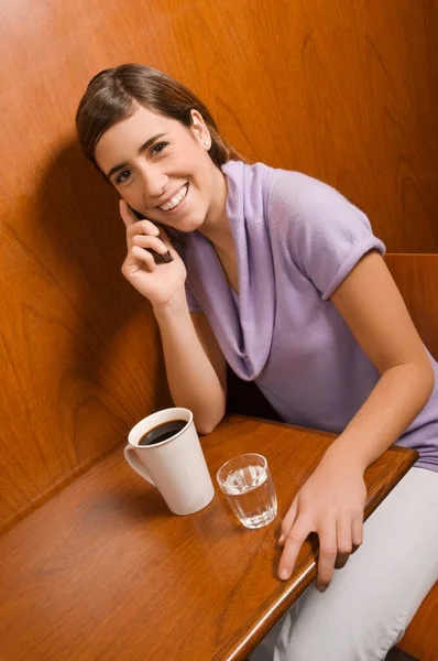 Jovem Mulher Bebendo Café Sorrindo Enquanto Senta Mesa Café — Fotografia de Stock