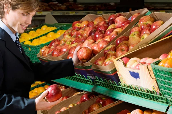 Młoda Kobieta Wybierając Czerwone Jabłka Supermarkecie — Zdjęcie stockowe