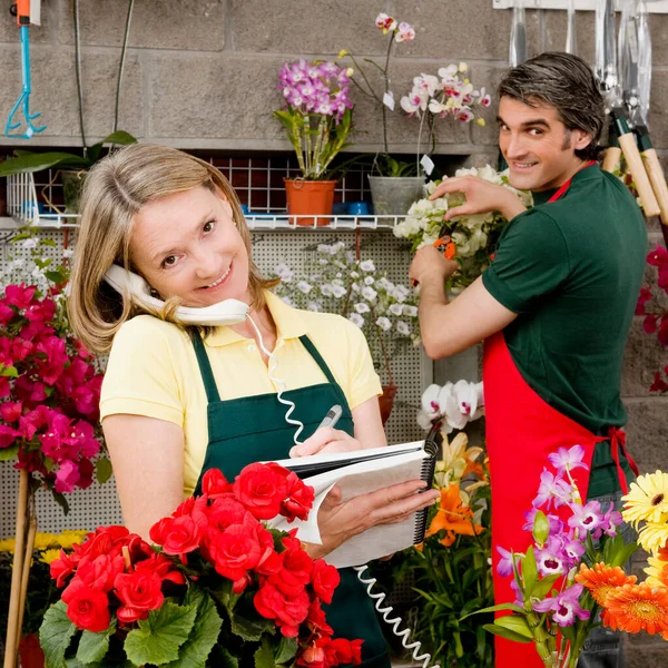 花店里有花的年轻夫妇 — 图库照片