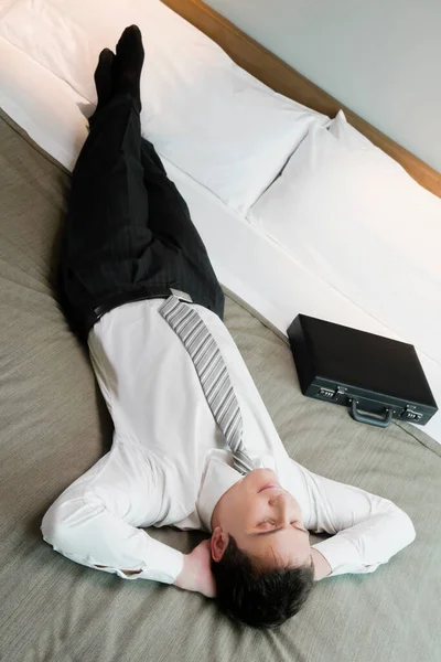 ベッドに横になってノートパソコンで働いている若い女性が — ストック写真
