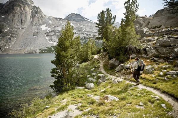 山の中でバックパックハイキングを持つ女性 — ストック写真