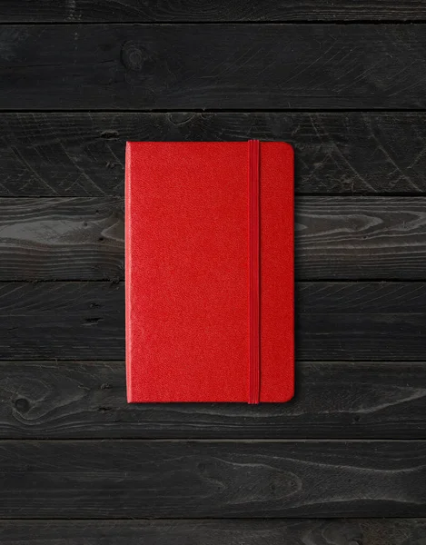 黒い木の背景に隔離された赤い閉じたノートブックモックアップ — ストック写真