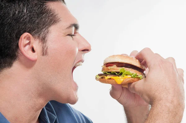 Uomo Mangiare Hamburger Con Hamburger Occhi Verdi — Foto Stock