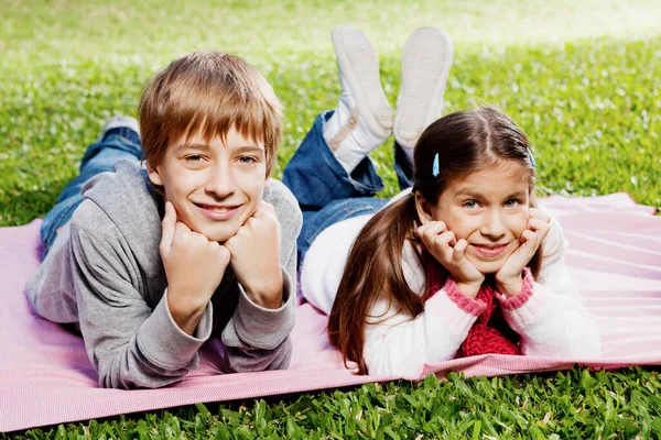 Niños Felices Tumbados Hierba Mirando Cámara — Foto de Stock