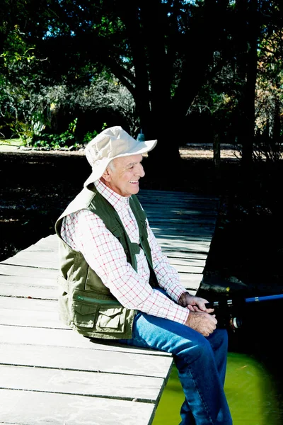 Nehrin Arkasında Sırt Çantalı Şapkalı Şapkalı Yaşlı Bir Adam Var — Stok fotoğraf