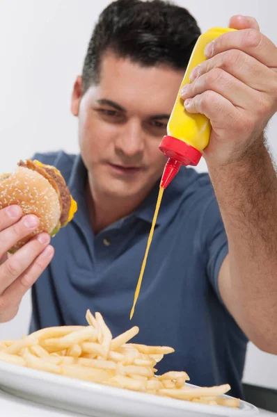 Homem Comendo Hambúrguer Com Batatas Fritas Legumes — Fotografia de Stock