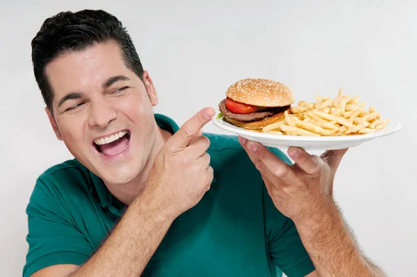 Hongerige Man Eten Hamburger Kijken Naar Camera Geïsoleerd Witte Achtergrond — Stockfoto