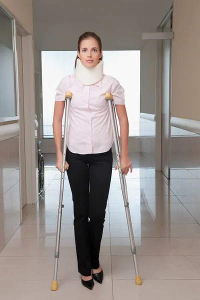 病院で松葉杖を持つ若い女性が — ストック写真
