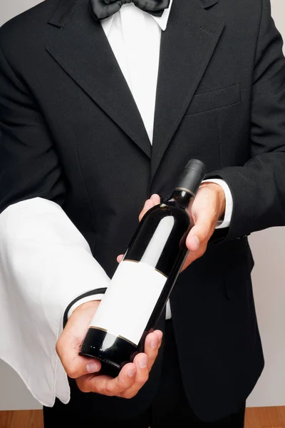 Biznesmen Trzymając Butelkę Wina Czerwonym Łukiem Białym Tle — Zdjęcie stockowe