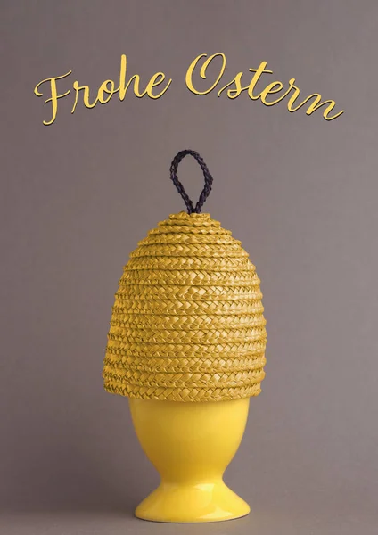 German happy Easter image, yellow egg cup with a yellow egg warmer, colors of the year 2021