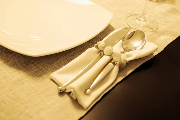 空のテーブルと木製の背景に刃物で白いプレート — ストック写真