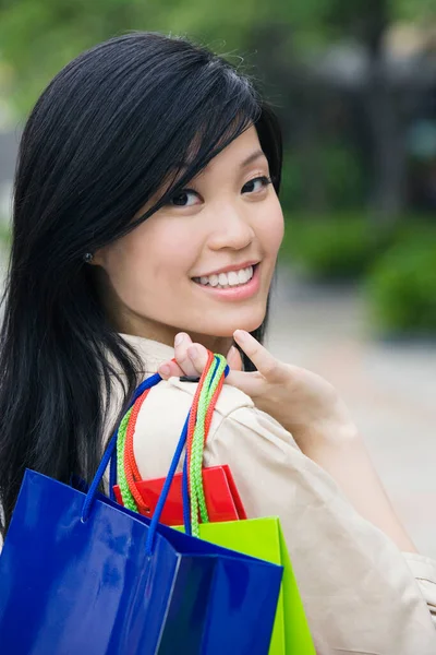 ショッピングバッグを手にした美しいアジア系女性の肖像画 — ストック写真