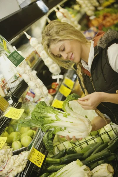 市場で野菜を選ぶ女性は — ストック写真