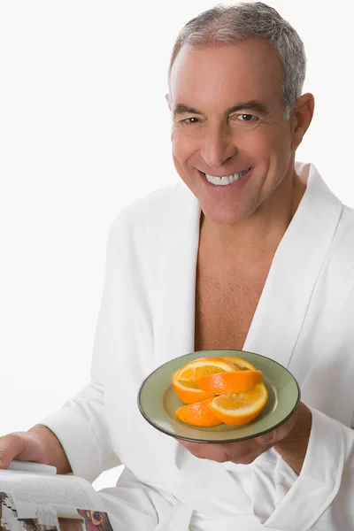 一个拿着一碗柠檬的成熟男人的肖像 — 图库照片