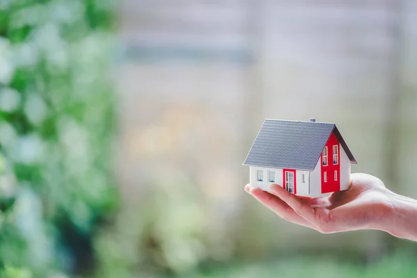 新しい家と家のコンセプト 男性の手で屋外の赤い家のモデル — ストック写真