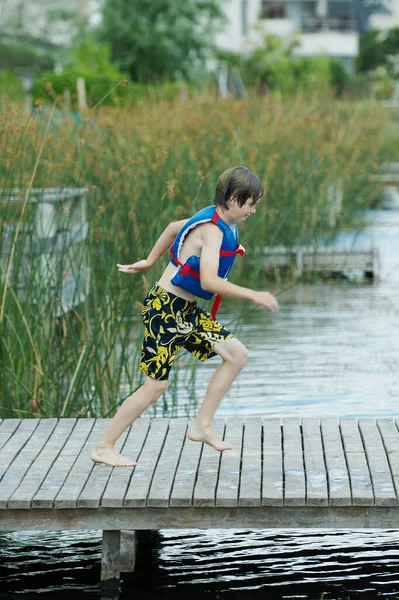 川を飛び跳ねる少年 — ストック写真