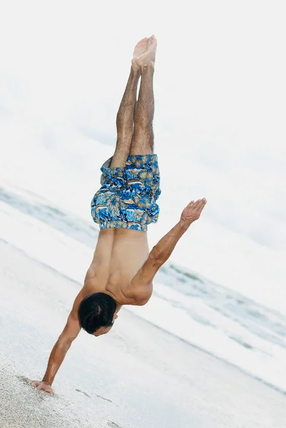 Νεαρός Άνδρας Κάνει Ασκήσεις Γιόγκα Στην Παραλία — Φωτογραφία Αρχείου