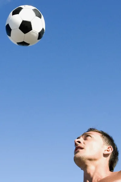 青空を背景にボールを持つ若い男 — ストック写真