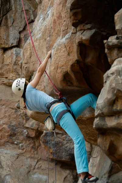 若い男が山の中の岩に登り — ストック写真
