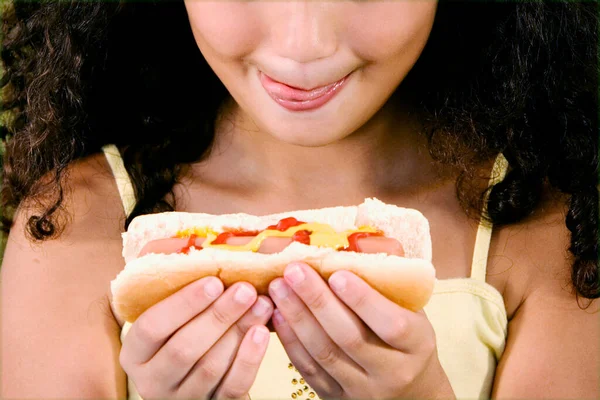 Close Uma Menina Segurando Cachorro Quente Furando Sua Língua Para — Fotografia de Stock