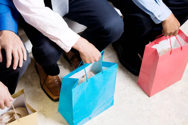 Χαμηλή Άποψη Τμήμα Των Τριών Επιχειρηματιών Κάθεται Τσάντες Ψώνια — Φωτογραφία Αρχείου