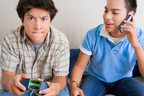 Primer Plano Joven Jugando Videojuegos Con Otro Joven Hablando Teléfono —  Fotos de Stock