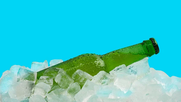 青い背景に隔離された小売ディスプレイで氷のキューブに冷たいラガービールの1つの緑のガラスボトルを閉じます 低角度側のビュー — ストック写真