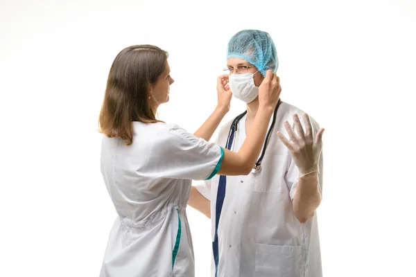 Krankenschwester Setzt Medizinische Maske Auf Chirurgen Gesicht Isoliert Auf Weiß — Stockfoto